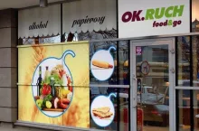 Na zdj. szyld OK.RUCH Food&amp;go wklejony na sklep dziś działający pod logo Superac (fot. materiały prasowe Ruchu, fotomontaż: wiadomoscihandlowe.pl)