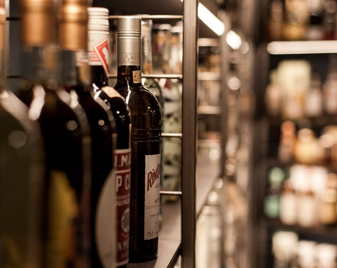 Półka z alkoholami w sklepie (Unsplash.com/Marco Chilese)