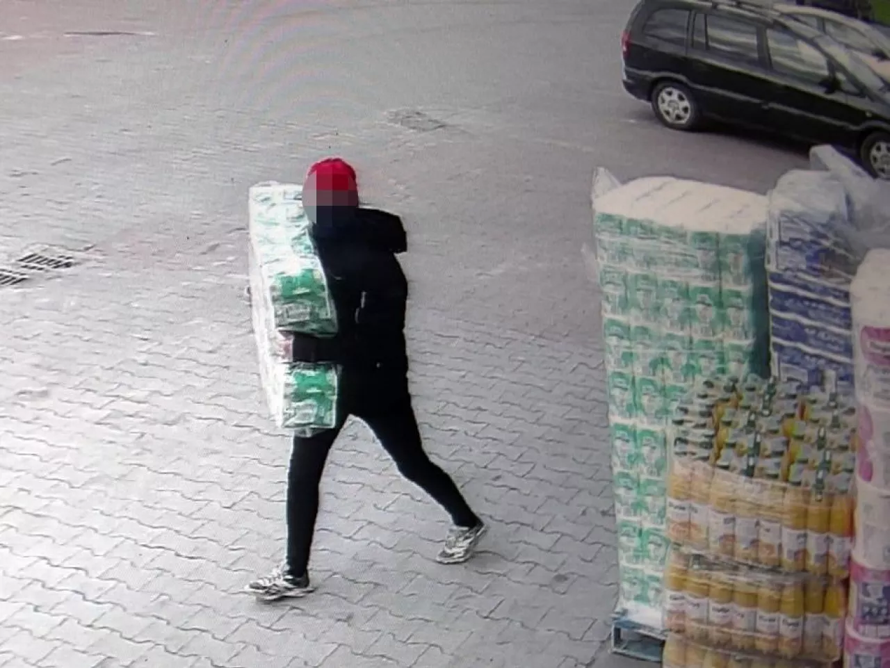 Kobieta zabierająca papier toaletowy sprzed sklepu/zdjęcie z monitoringu (fot. Policja)