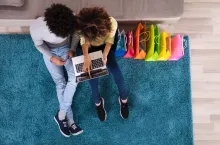 &lt;p&gt;Young Couple Shopping Online On Laptop With Multi Colored Shopping Bags On Sofa&lt;/p&gt;