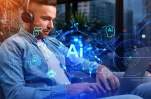 &lt;p&gt;Businessman typing on laptop with headphones, AI hologram with chatbot and online communication, tech lines and connection. Concept of work process and virtual assistant&lt;/p&gt;