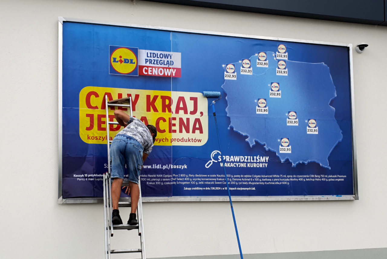 Wyklejanie plakatu reklamowego na sklepie sieci Lidl, fot. materiały własne