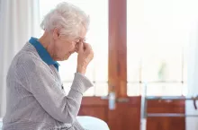 Senior woman, headache and stress with anxiety in retirement house, lonely and sad with mental heal.