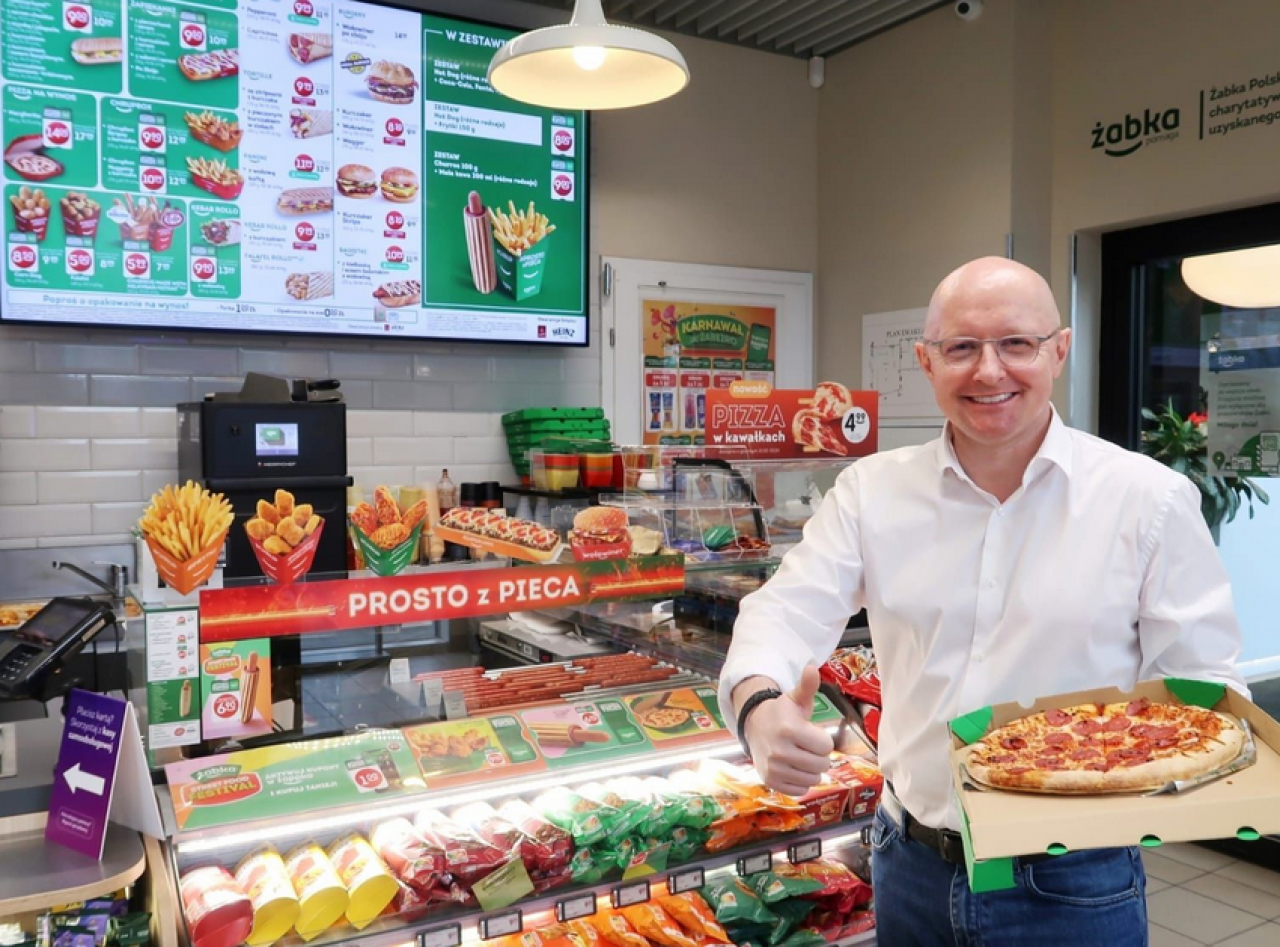 Adam Manikowski, wiceprezes zarządu, dyrektor zarządzający Żabka Polska zaprasza klientów na pizzę, fot. Żabka Polska