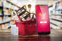 Cosmetics and beauty products buying online concept. Shopping basket with makeup products and mobile phone on shelf of cosmaetics shop. 3d illustration