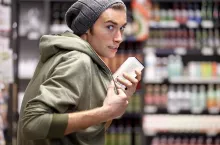 shoplifter in the electronic store supermarket stealing new gadget