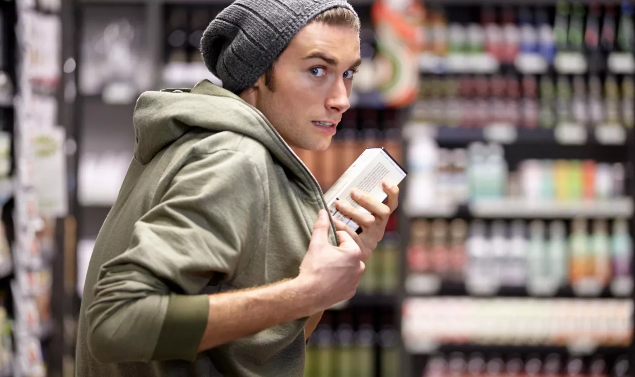 shoplifter in the electronic store supermarket stealing new gadget