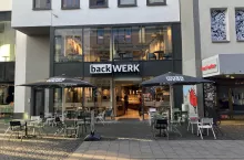 Sklep BackWerk w centrum miasta ilustruje swoją rolę łączącą piekarnię z punktem sprzedaży detalicznej, z miejscami siedzącymi w stylu kawiarnianym wewnątrz i na zewnątrz, w strefie dla pieszych. (fot. Sebastian Rennack)