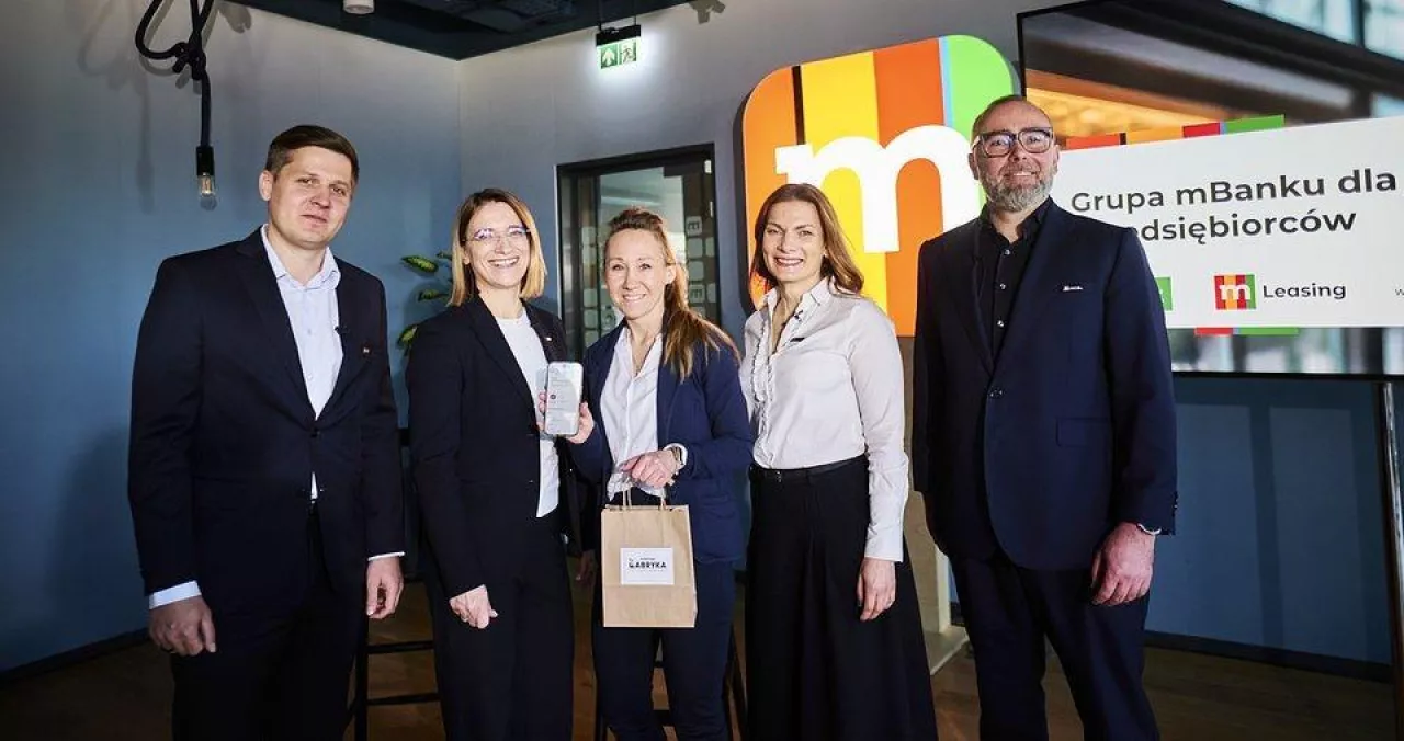 Krzysztof Bratos, wiceprezes mBanku ds. bankowości detalicznej; Aleksandra Buczkowska, dyrektorka zarządzająca ds. produktów i segmentów klienckich w pionie bankowości detalicznej mBanku; Katarzyna Szerling, wiceprezeska mLeasing; Cezary Raczyński, prezes spółki mLeasing wraz z klientką banku (pośrodku)