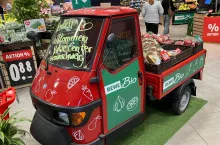 Klasyczny skuter Vespacar przy wejściu do sklepu Rewe sygnalizuje wieloletnie, lokalne zakorzenienie. Przedstawia sprzedawcę jako zaufanego sąsiada, a nie anonimowego operatora sieci. (Fot. Sebastian Rennack)